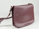 a close up of a purple purse with a strap on a white background