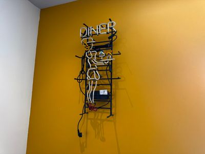 a neon sign that says dinner on the wall