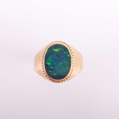 une bague en or sertie d'une pierre oplite au centre