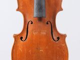 an old violin sitting on top of a wooden stand