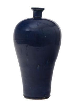 un vase bleu posé sur une surface blanche