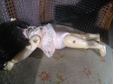 a doll that is laying on a chair with a teddy bear