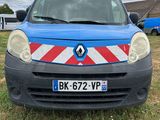 une camionnette bleue avec une bande rouge et blanche garée dans un champ