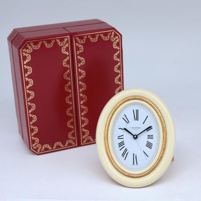 une petite horloge posée à côté d'une boîte rouge