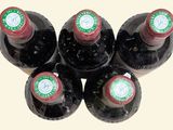 six bottles of wine are lined up in a row on a table