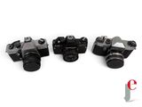 four cameras are lined up in a row on a white surface