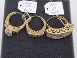 trois paires de bagues en or serties de diamants, posées sur un tissu noir