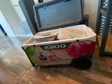 a cooler sitting on top of a cart on the floor