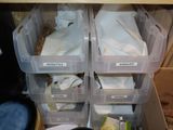 many plastic bins filled with various items in a cabinet