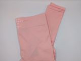 un legging rose posé sur une surface blanche, avec un fond bleu