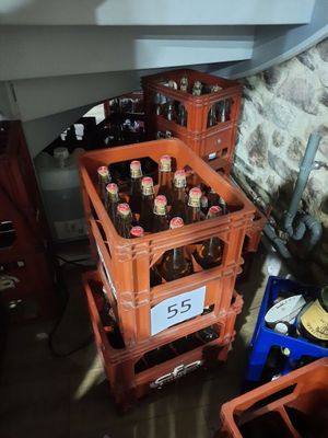 Des caisses de bière sont empilées les unes sur les autres dans une pièce