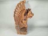 carved wooden sculpture of a bird with wings on a white surface