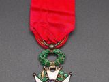 a close up of a medal on a table with a red ribbon