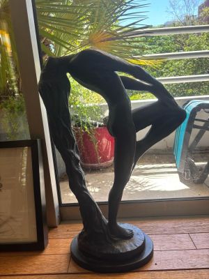 a statue of a man holding a surfboard in front of a window