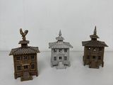 trois bâtiments miniatures sont posés sur une surface blanche