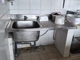 une cuisine équipée d'un évier, d'une cuisinière et d'autres éléments