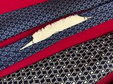 three ties with different patterns are laying on a red surface