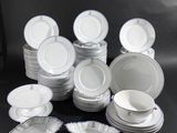 beaucoup d'assiettes et de bols blancs sur une table