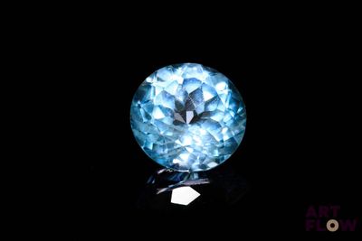 a close up of a blue diamond on a black surface