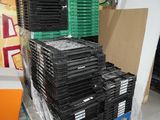 de nombreuses piles de CD empilées sur une palette dans un entrepôt