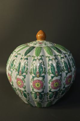 a white vase with a green and pink pattern on it