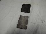 two pieces of metal sitting on a bed next to each other