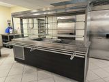a kitchen with stainless steel counter tops and a glass display case