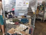 une femme debout à côté d'une cage remplie d'animaux en peluche
