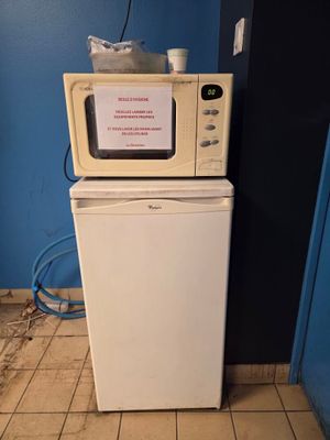 un micro-ondes posé sur un réfrigérateur dans une cuisine