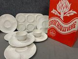 de nombreuses assiettes et tasses sur la table, à côté d'une boîte rouge