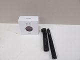 a black pen sitting next to a white box on a table