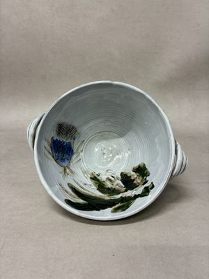 a white bowl with blue flowers in it on a table