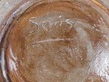 une assiette marron et bleue posée sur une table blanche