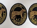 three black and gold embroidered badges of a dog and a cat