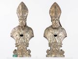 pair of silver colored busts of a priest and a woman