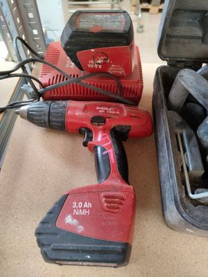 two electric tools sitting on a table next to a tool case