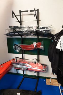 un portant avec des vêtements et un kayak dans une pièce