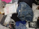 a pile of clothes and other items on a bed