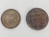 an image of two old coins sitting side by side on a white surface