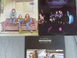 Trois albums du groupe The Eagles sont posés sur un lit