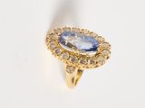 an image of a gold ring with a blue stone surrounded by diamonds