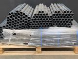 a pile of pipes sitting on top of a pallet in a warehouse