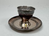 une tasse et une soucoupe en argent posées sur un plateau en argent