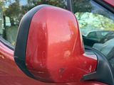a red car that has a mirror on the side of it