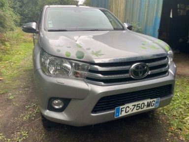 the toyota hilux is parked in front of a garage