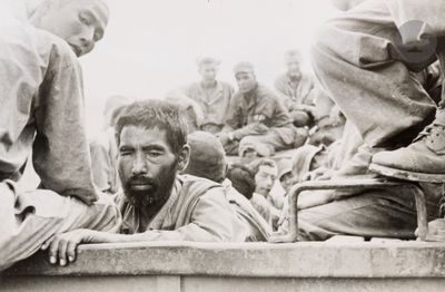 several soldiers are sitting on the side of a truck with a man with a beard