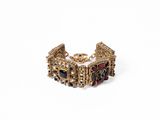 gros plan d'un bracelet en or sur fond blanc
