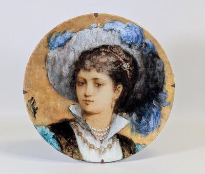 une assiette sur laquelle est représentée une femme portant un chapeau bleu
