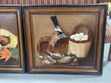 two framed pictures of a bird and a basket of eggs