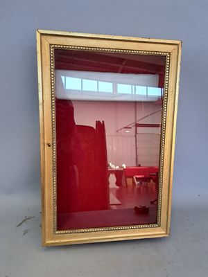 a mirror that is sitting on the floor in front of a wall